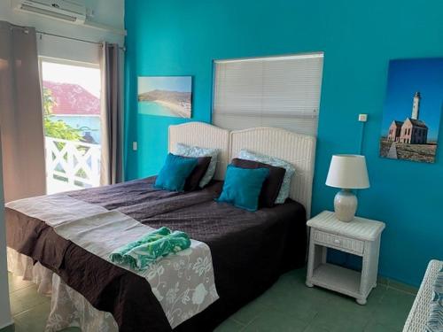 um quarto com uma cama com paredes azuis e uma janela em Blue Lagoon Apartment em Lagun