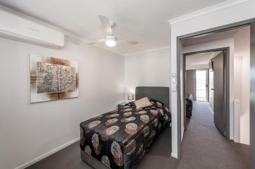 1 dormitorio con 1 cama y ventilador de techo en Athena Motel Apartments, en Toowoomba