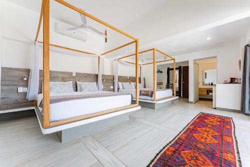 a bedroom with a four poster bed and a rug at Villa Aikia (Adults Suites A/C) in Zipolite