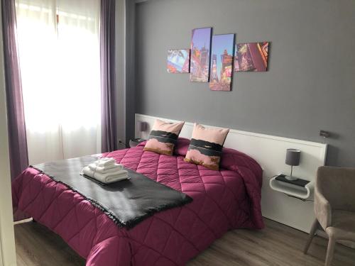 a bedroom with a pink bed with a pink blanket at HOME52 in Rende