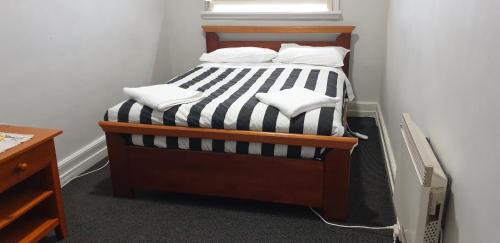 a bed with black and white striped sheets and pillows at The Eastern Hotel Accommodation in Ballarat