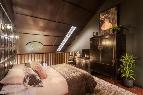 a bedroom with a large bed with a wooden headboard at The Barn, designers dream beach hideaway in Waihi Beach