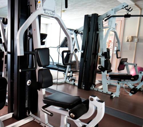 a gym with several tread machines and a simulator at Atlantic Host Hotel, Trademark Collection by Wyndham in Bathurst