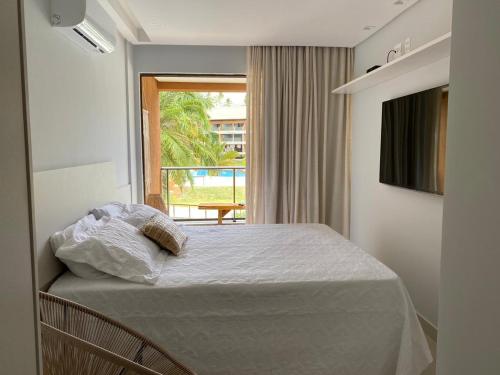 ein Schlafzimmer mit einem Bett und einem Fenster mit Aussicht in der Unterkunft Flat 113 Eco Resort Praia dos Carneiros in Praia dos Carneiros