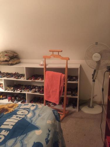 a bedroom with a bed and a shelf with shoes at Marianela in Los Ángeles
