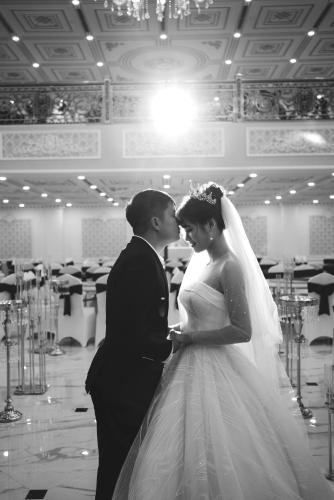 a bride and groom kissing in a room at Khách sạn Minh Phú Diamond Palace in Diễn Châu