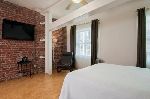a bedroom with a bed and a brick wall at Herbert Hotel in San Francisco