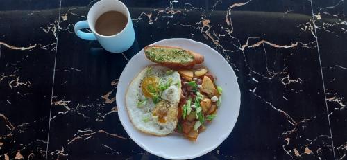 a plate of food with toast and a cup of coffee at Bella's Beach Resort Apartment 8 in Bauang