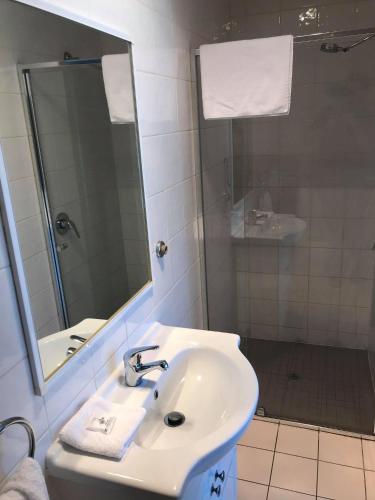 a white bathroom with a sink and a mirror at Guiding Star Motel & Hotel in Brooklyn