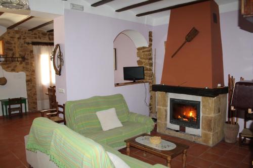 sala de estar con sofá y chimenea en Casa Rural Ca Ferminet & Cabañas de montaña La Garriga, en Benisili