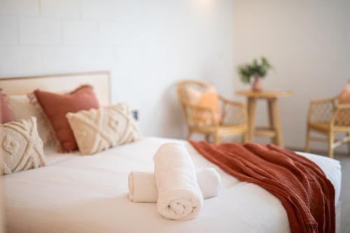 Una cama con dos toallas enrolladas encima. en Anglesea Riverside Motel, en Anglesea