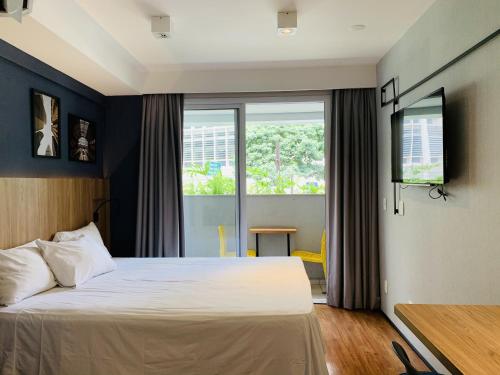 a bedroom with a bed and a large window at Downtown São Luis Akilê in Sao Paulo