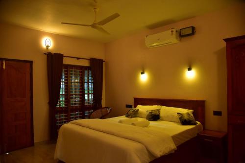 a bedroom with a bed and a ceiling fan at Royal KazBay Beach Resort in Varkala