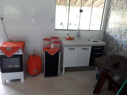 uma cozinha com um lavatório e um balcão com um fogão em Pousada Chácara Família H em Caratinga