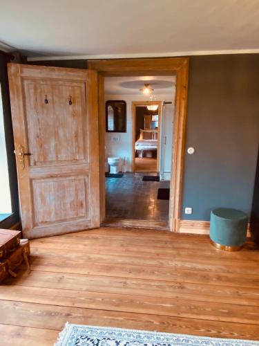 a room with a wooden door and a bedroom at Gutshaus Klein kussewitz in Klein Kussewitz