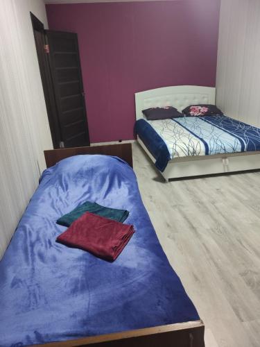 - une chambre avec 2 lits et une couette bleue dans l'établissement Затишна квартира, à Tcherkassy