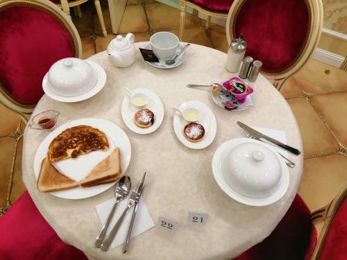 una mesa blanca con platos de comida. en Гостиница Альвита Краснодар Центр, en Krasnodar