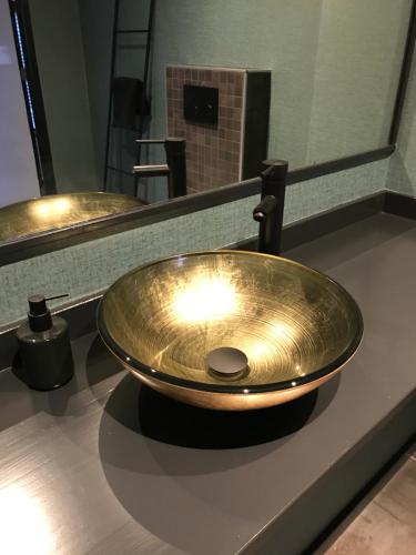 a brass sink on a counter in a bathroom at De Tuinschuur in Empe