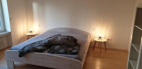 a bed in a room with two candles on two tables at Quiet business flat or vacation home in Bad Urach in Bad Urach