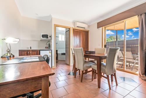 a kitchen and dining room with a table and chairs at Georgian Motor Lodge in Echuca
