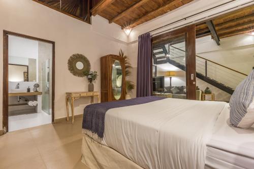 sypialnia z dużym łóżkiem i schodami w obiekcie Villa Bunga 1 w mieście Seminyak