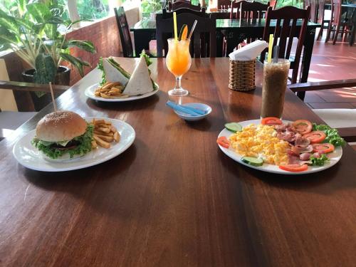 a wooden table with two plates of food on it at Sunlight Bungalow in Phu Quoc