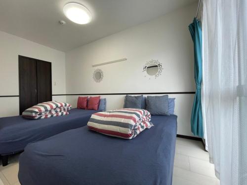 2 camas con almohadas en una habitación en EX Itoman Apartment 302 en Itoman
