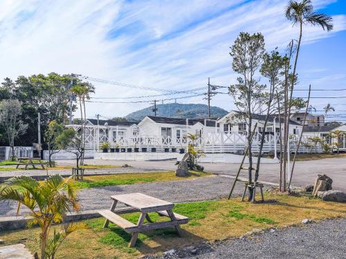 a picnic table in a park with a building at コテージスターハウス今帰仁 in Nakijin