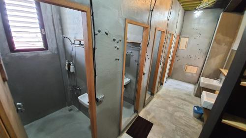 a bathroom with a shower and two sinks and a toilet at 缽割貓點點 青旅 DianDian hostel in Puli