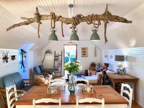 a living room with a wooden table and chairs at Renovated Fishermans Cottage in Hermanus