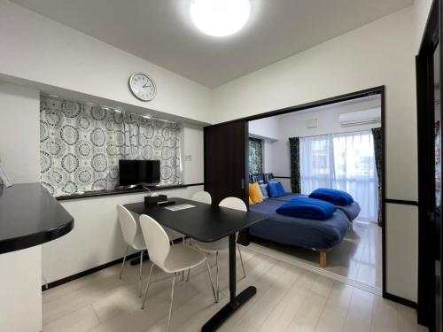 1 dormitorio con 1 cama, mesa y sillas en EX Itoman Apartment 301, en Itoman