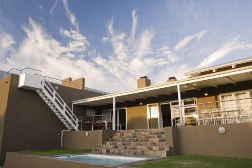 a house with a swimming pool in front of it at Brander View in Hermanus