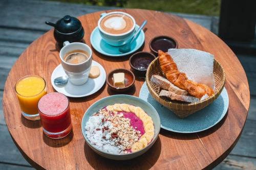 a wooden table with breakfast foods and coffee on it at Segara Lombok Beach Resort in Selong Belanak