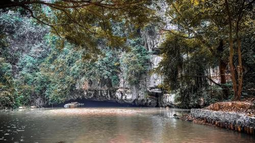 a river with a cave in the middle of it at Tuan Nam Homestay in Ninh Binh