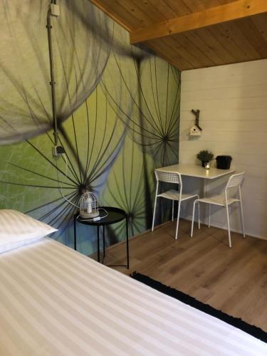 a room with a bed and a table and chairs at Chalets Maria Garden in Zevenbergen