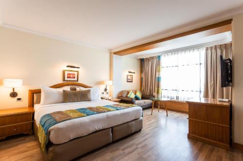 une chambre d'hôtel avec un lit et une télévision dans l'établissement The Maya Hotel, à Jalandhar