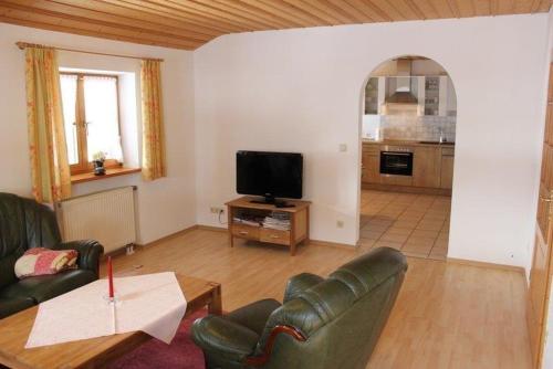 a living room with a couch and a television at Gasthof Zum Ott in Staudach-Egerndach