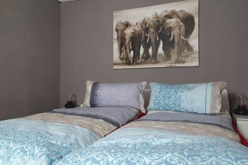 1 dormitorio con 2 camas y una pintura de elefantes en Stadtb,BurgGleiberg,Whirlpool,2xBad,3ZimmerNetflix, en Gleiberg