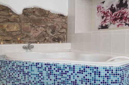 y baño con bañera y pared de piedra. en Stadtb,BurgGleiberg,Whirlpool,2xBad,3ZimmerNetflix, en Gleiberg