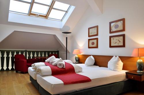 een slaapkamer met een groot bed en een rode deken bij Hotel U Bílého koně in Loket