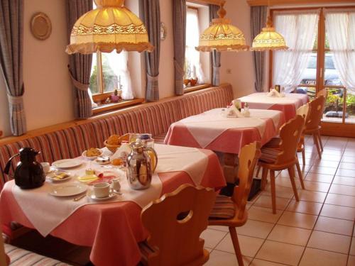 a restaurant with two tables with red and white tablecloths at Gästehaus Schwarzlofer in Reit im Winkl