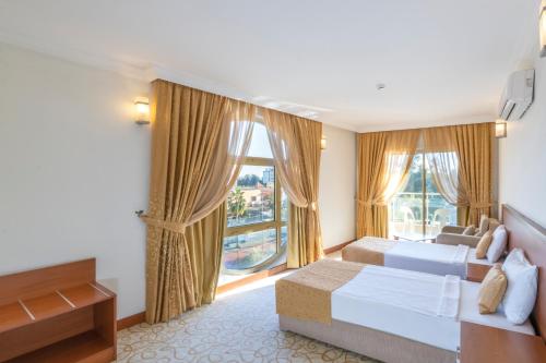コナクリにあるMiarosa Konakli Gardenのベッド2台と大きな窓が備わるホテルルームです。