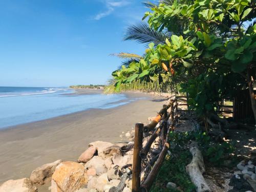a fence on a beach near the ocean at El Marabu Chill'n Surf in Aposentillo