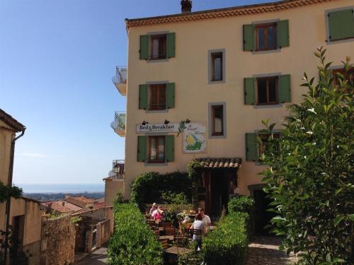 a building with people sitting at tables in front of it at The FrogS' House - Yoga Retreat in Saint-Jeannet