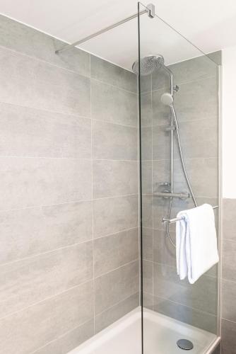 a shower with a glass door in a bathroom at Radisson Blu Hotel Dortmund in Dortmund