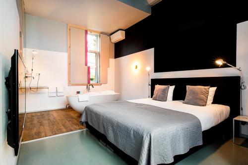 a bedroom with a bed and a tub and a sink at Landgoed Kasteel de Hoogenweerth in Maastricht