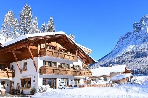a house in the snow with mountains in the background at ZIRBENNEST Martha in Biberwier