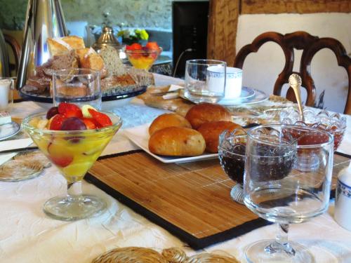 einen Tisch mit Teller mit Speisen und Weingläsern darauf in der Unterkunft B&B de charme La Maison des 5 Temps in Ferrette