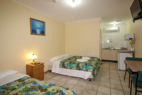 ein Hotelzimmer mit 2 Betten und einer Küche in der Unterkunft iGrand Motel in Moree