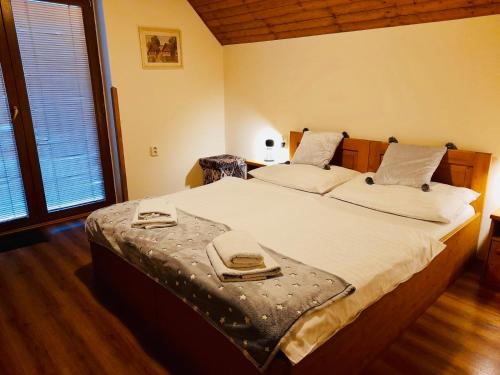 a bedroom with a large bed with two towels on it at Restaurant a penzion Pod Draci skalou in Karlštejn